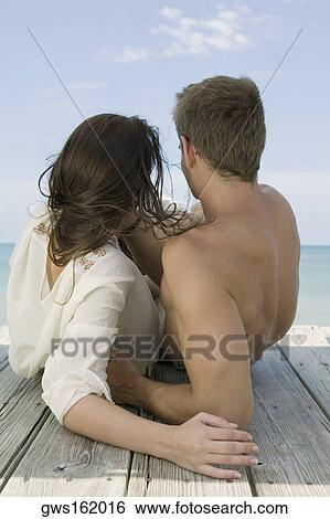 Close-up of a young couple lying on a pier View Large Photo Image Stock Photograph - Close-up of a young couple lying on a pier. Fotosearch