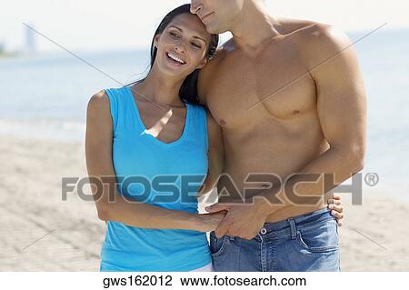 Close-up of a young couple standing on the beach View Large Photo Image Stock Image - Close-up of a young couple standing on the beach. Fotosearch