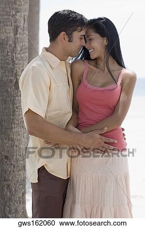 Stock Image - Close-up of a young man embracing a young woman. Fotosearch