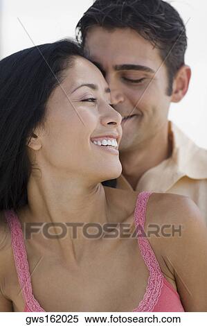 Close-up of a young man embracing a young woman from behind View Large Photo Image Stock Photography - Close-up of a young man embracing a young woman from behind. Fotosearch