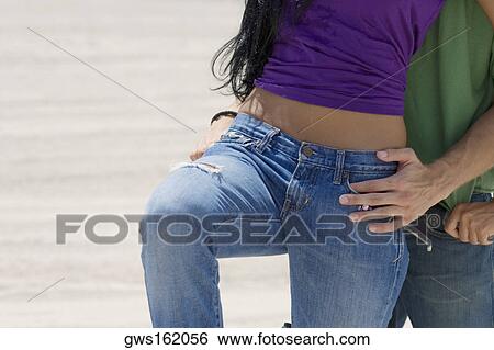 Mid section view of a young woman leaning on a bicycle with a young man View Large Photo Image Stock Photograph - Mid section view of a young woman leaning on a bicycle with a young man. Fotosearch