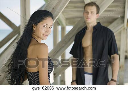 Portrait of a young woman standing with a young man View Large Photo Image Stock Photograph - Portrait of a young woman standing with a young man. Fotosearch