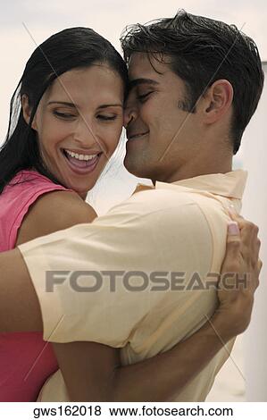 Side profile of a young woman and a mid adult man embracing each other View Large Photo Image Stock Photo - Side profile of a young woman and a mid adult man embracing each other. Fotosearch
