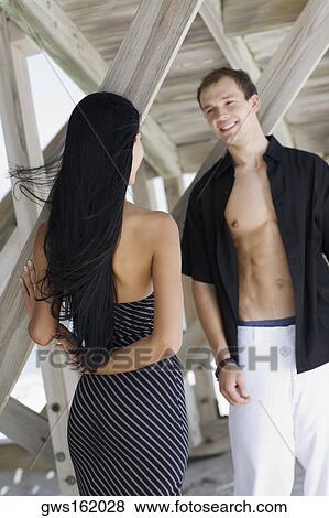 Young couple looking at each other and smiling View Large Photo Image Stock Photo - Young couple looking at each other and smiling. Fotosearch