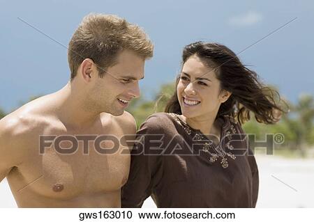 Close-up of a young couple smiling View Large Photo Image Stock Image - Close-up of a young couple smiling. Fotosearch