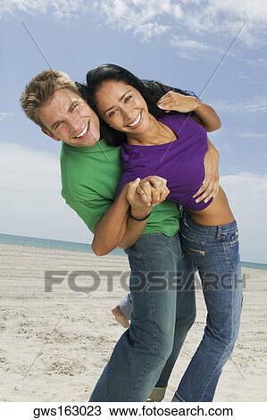 Portrait of a young couple dancing on the beach and smiling View Large Photo Image Stock Image - Portrait of a young couple dancing on the beach and smiling. Fotosearch