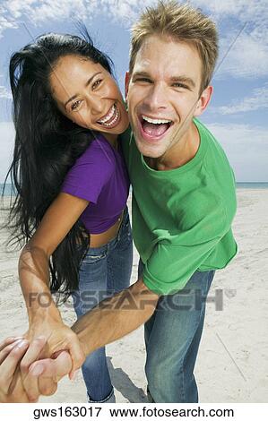 Portrait of a young couple dancing on the beach View Large Photo Image Stock Photo - Portrait of a young couple dancing on the beach. Fotosearch