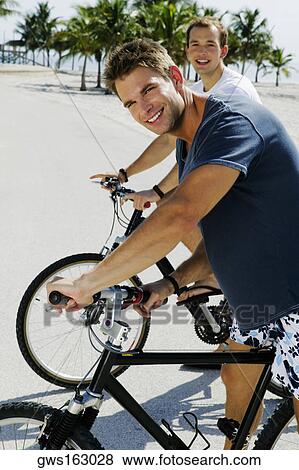 Stock Photo - Portrait of two young men on bicycles. Fotosearch