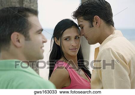 Young man looking at a young couple View Large Photo Image Stock Image - Young man looking at a young couple. Fotosearch