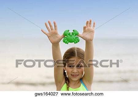 Close-up of a girl holding a toy crab View Large Photo Image Stock Photo - Close-up of a girl holding a toy crab. Fotosearch