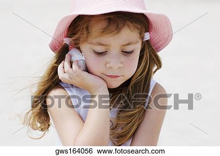 Close-up of a girl listening to a seashell View Large Photo Image Stock Photograph - Close-up of a girl listening to a seashell. Fotosearch