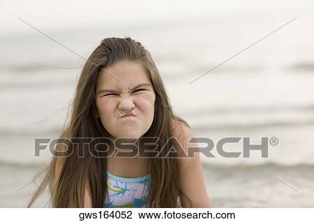 Close-up of a girl making a face on the beach View Large Photo Image Stock Image - Close-up of a girl making a face on the beach . Fotosearch