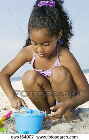 Close-up of a girl playing with sand on the beach View Large Photo Image Stock Photo - Close-up of a girl playing with sand on the beach. Fotosearch