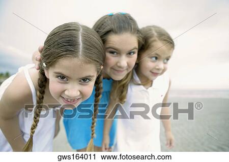 Close-up of three girls standing together on the beach View Large Photo Image Stock Image - Close-up of three girls standing together on the beach. Fotosearch