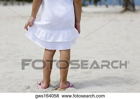 Low section view of a girl standing on the beach View Large Photo Image Stock Photo - Low section view of a girl standing on the beach. Fotosearch