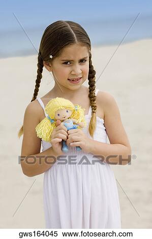 Stock Photography - Portrait of a girl holding a doll. Fotosearch