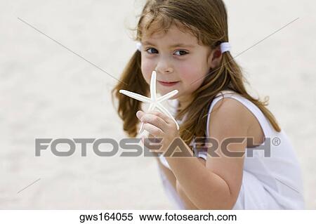 Portrait of a girl holding a starfish View Large Photo Image Stock Photography - Portrait of a girl holding a starfish. Fotosearch