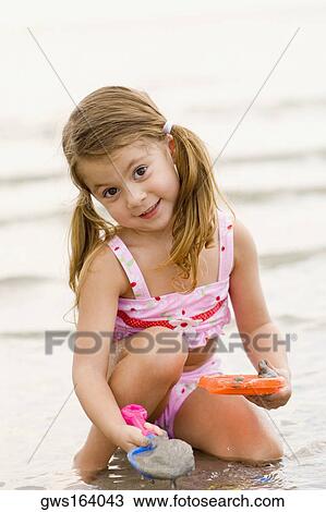Portrait of a girl playing with toys on the beach View Large Photo Image Stock Image - Portrait of a girl playing with toys on the beach. Fotosearch