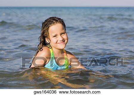 Stock Photograph - Portrait of a girl smiling in the sea. Fotosearch