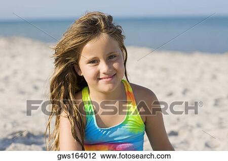 Stock Image - Portrait of a girl smiling on the beach. Fotosearch