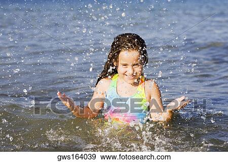 Portrait of a girl splashing water in the sea View Large Photo Image Stock Photo - Portrait of a girl splashing water in the sea. Fotosearch