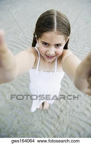 Picture - Portrait of a girl standing on the beach and smiling. Fotosearch