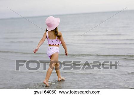 Rear view of a girl walking on the beach View Large Photo Image Stock Image - Rear view of a girl walking on the beach. Fotosearch