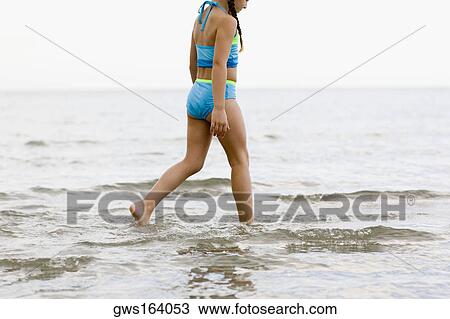 Side profile of a girl wading in water on the beach View Large Photo Image Stock Image - Side profile of a girl wading in water on the beach. Fotosearch