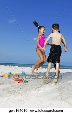 Two girls and a boy playing on the beach View Large Photo Image Stock Image - Two girls and a boy playing on the beach. Fotosearch