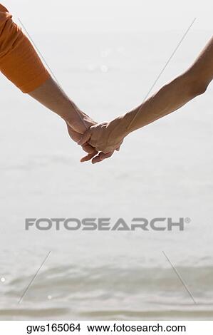 Close-up of a man and a woman holding hands View Large Photo Image Picture - Close-up of a man and a woman holding hands. Fotosearch