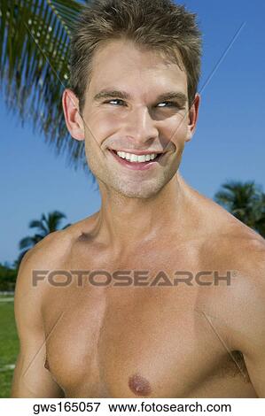 Close-up of a young man smiling View Large Photo Image Stock Photo - Close-up of a young man smiling. Fotosearch