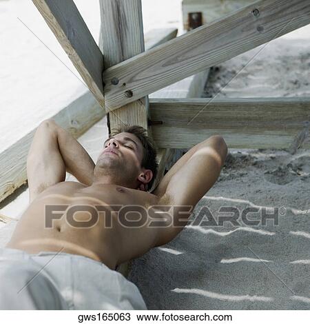 High angle view of a young man sleeping under a pier View Large Photo Image Stock Image - High angle view of a young man sleeping under a pier. Fotosearch