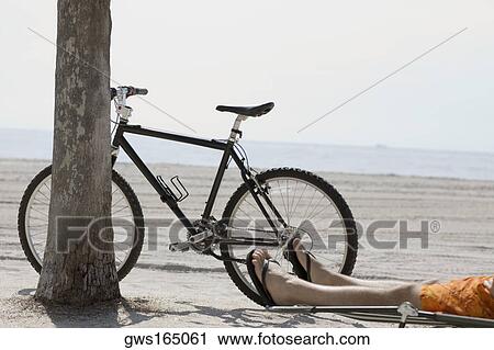 Low section view of a man relaxing on the beach View Large Photo Image Stock Image - Low section view of a man relaxing on the beach. Fotosearch