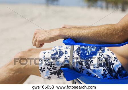 Mid section view of a man sitting in an armchair on the beach View Large Photo Image Stock Image - Mid section view of a man sitting in an armchair on the beach. Fotosearch