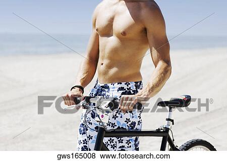 Mid section view of a man with a bicycle on the beach View Large Photo Image Stock Photo - Mid section view of a man with a bicycle on the beach. Fotosearch