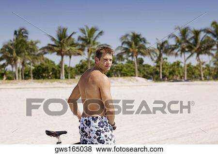 Portrait of a young man with a bicycle on the beach View Large Photo Image Stock Photo - Portrait of a young man with a bicycle on the beach. Fotosearch