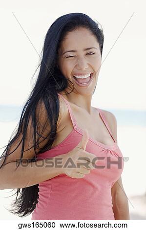 Portrait of a young woman showing a thumbs up sign View Large Photo Image Stock Image - Portrait of a young woman showing a thumbs up sign. Fotosearch