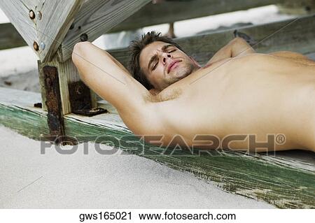 Side profile of a young man sleeping under a pier View Large Photo Image Stock Image - Side profile of a young man sleeping under a pier. Fotosearch