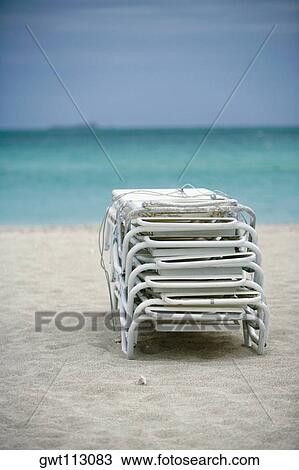 Stack of lounge chairs on the beach View Large Photo Image Stock Image - Stack of lounge chairs on the beach. Fotosearch