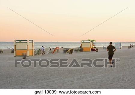 Tourists on the beach at dusk View Large Photo Image Stock Photo - Tourists on the beach at dusk. Fotosearch