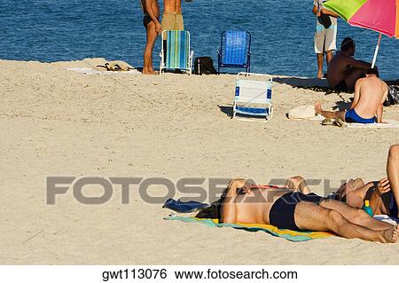 Tourists on the beach View Large Photo Image Stock Photograph - Tourists on the beach. Fotosearch