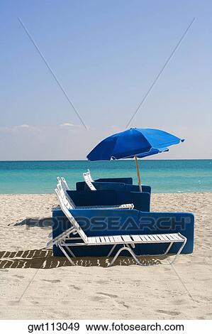 Umbrella and a lounge chair on the beach View Large Photo Image Stock Photo - Umbrella and a lounge chair on the beach. Fotosearch