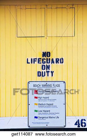 Stock Photo - Close-up of a warning sign on a lifeguard hut. Fotosearch