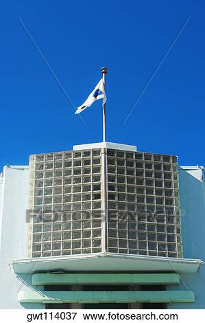 Low angle view of a flag fluttering on the top of a building View Large Photo Image Stock Photo - Low angle view of a flag fluttering on the top of a building. Fotosearch