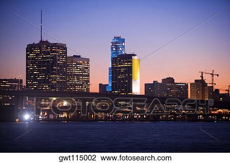 Buildings at the waterfront lit up at dusk, Miami, Florida, USA View Large Photo Image Stock Image - Buildings at the waterfront lit up at dusk, Miami, Florida, USA. Fotosearch