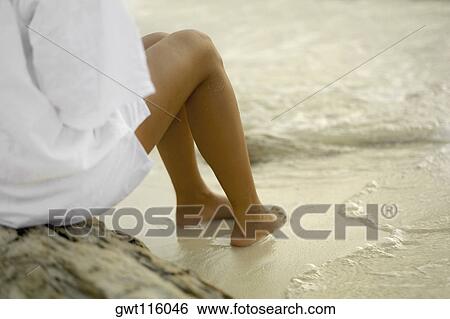 Close-up of a young woman sitting on a rock View Large Photo Image Stock Photograph - Close-up of a young woman sitting on a rock. Fotosearch