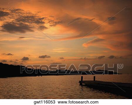 Pier in the sea at sunset View Large Photo Image Stock Image - Pier in the sea at sunset. Fotosearch
