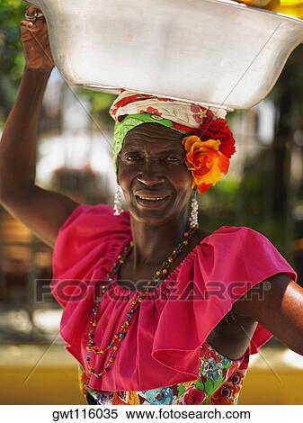 Portrait of a market vendor carrying a basket on her head, Cartagena, Colombia View Large Photo Image Stock Photography - Portrait of a market vendor carrying a basket on her head, Cartagena, Colombia. Fotosearch