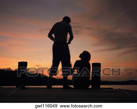 Silhouette of a man and a woman on a pier View Large Photo Image Stock Photo - Silhouette of a man and a woman on a pier. Fotosearch