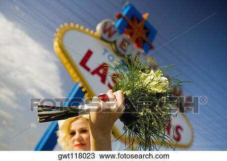 Low angle view of a mid adult woman holding a bouquet of flowers, Las Vegas, Nevada, USA View Large Photo Image Stock Image - Low angle view of a mid adult woman holding a bouquet of flowers, Las Vegas, Nevada, USA. Fotosearch